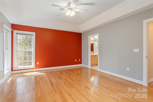 spare room with light wood finished floors, visible vents, ceiling fan, and baseboards