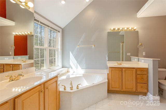 bathroom featuring a bath, toilet, lofted ceiling, and a sink