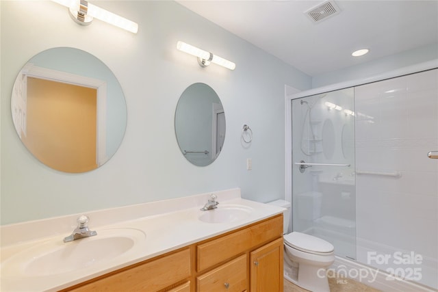 bathroom with visible vents, a shower stall, toilet, and a sink