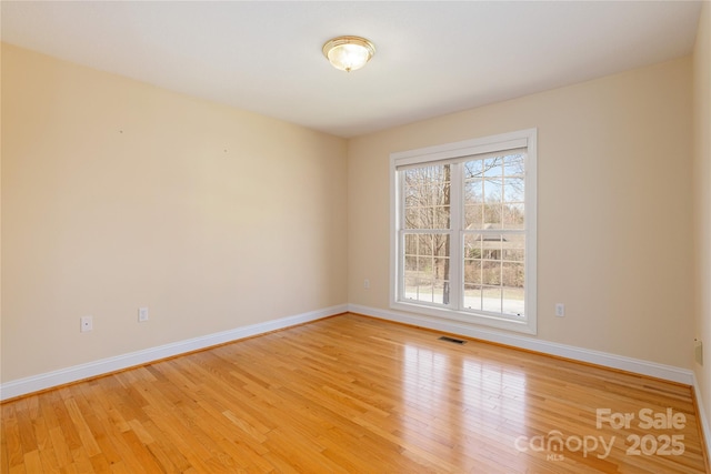 spare room with visible vents, baseboards, and light wood-style flooring