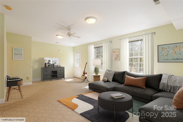 living room featuring visible vents, baseboards, light colored carpet, and ceiling fan