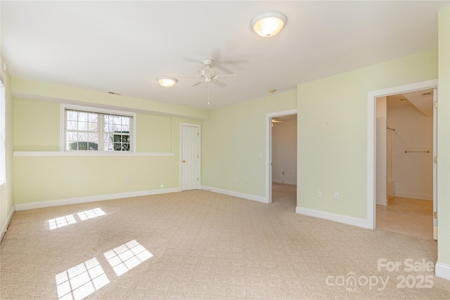 carpeted empty room featuring baseboards and ceiling fan