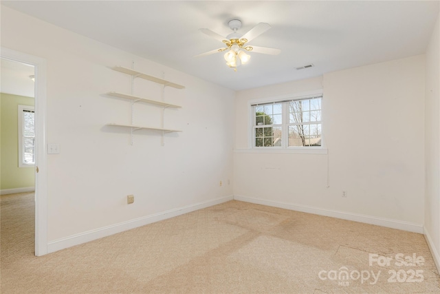 unfurnished room with ceiling fan, carpet, visible vents, and a healthy amount of sunlight