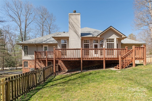 back of house with a yard, a deck, a chimney, and fence