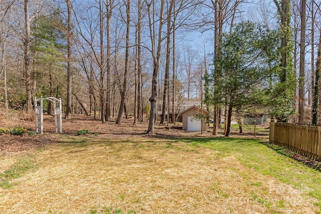 view of yard with an outbuilding, a storage unit, and fence