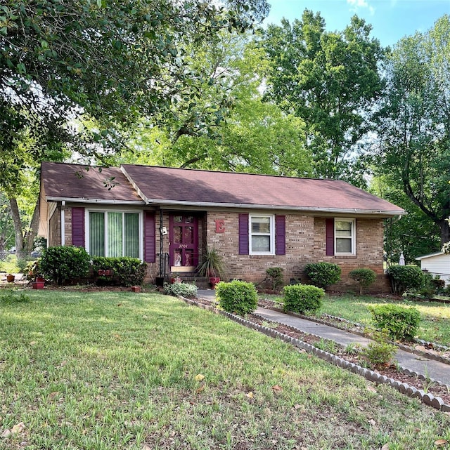 ranch-style home featuring brick siding and a front lawn