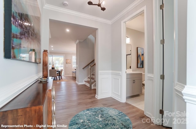 corridor featuring stairway, light wood-type flooring, and crown molding