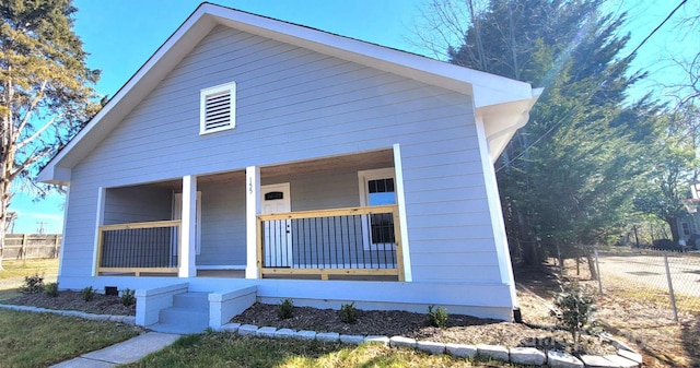 view of front of home featuring a porch and fence