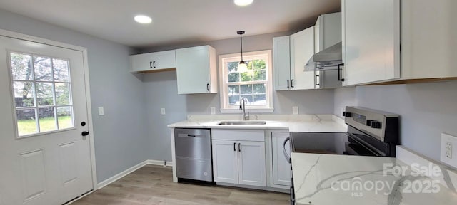 kitchen with extractor fan, stainless steel appliances, a sink, light wood-type flooring, and light stone countertops