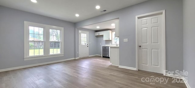 interior space with visible vents, a sink, baseboards, and wood finished floors