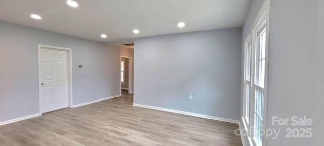 empty room featuring baseboards, light wood-type flooring, and recessed lighting