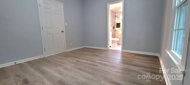 spare room with wood finished floors and baseboards