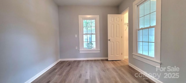 doorway featuring wood finished floors and baseboards