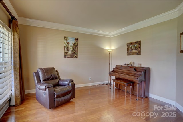 sitting room with light wood-type flooring, baseboards, and ornamental molding