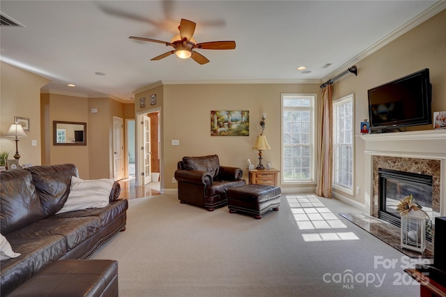 carpeted living area featuring visible vents, ornamental molding, baseboards, and a premium fireplace