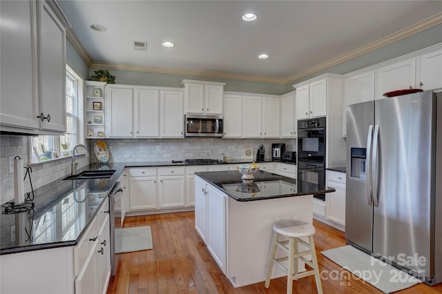 kitchen featuring a sink, ornamental molding, appliances with stainless steel finishes, white cabinets, and open shelves