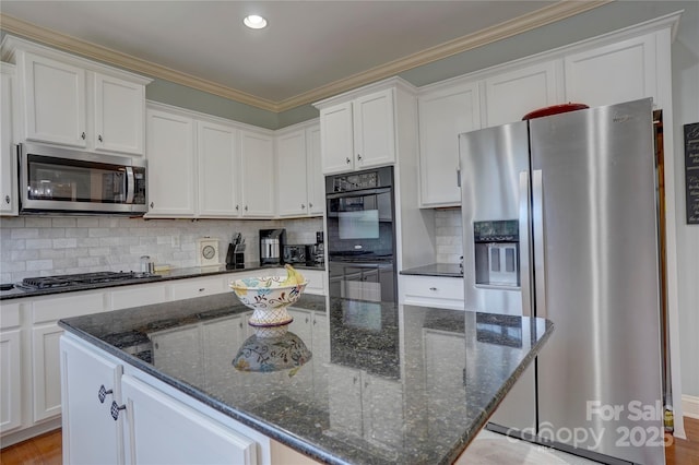 kitchen featuring stainless steel appliances, a kitchen island, and white cabinetry