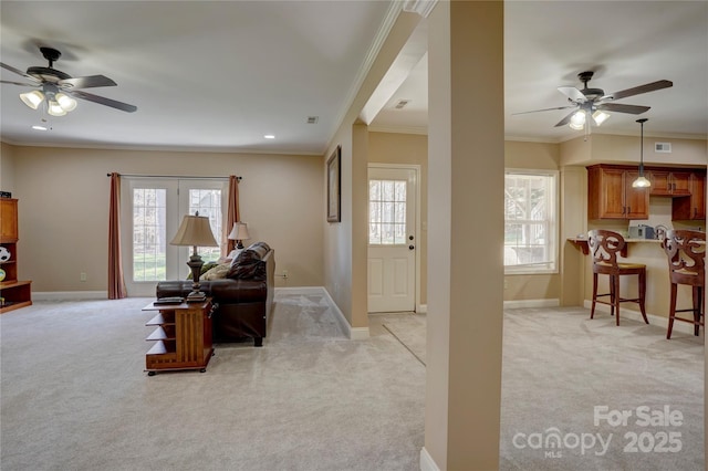 living area featuring light colored carpet and baseboards