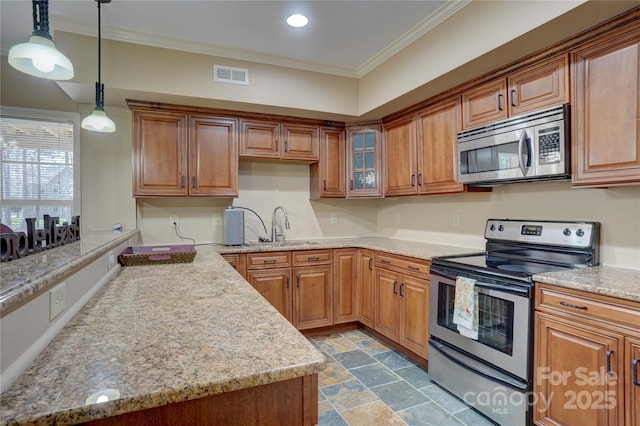 kitchen with a sink, visible vents, appliances with stainless steel finishes, and ornamental molding