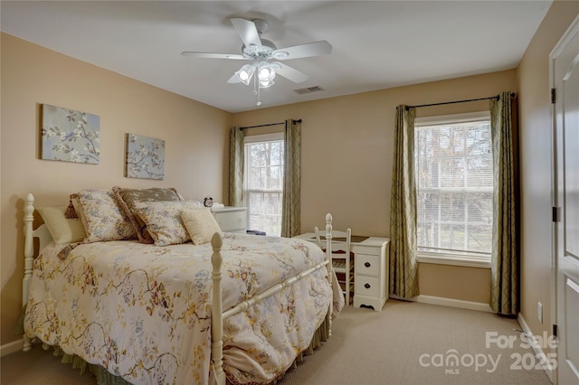 bedroom featuring visible vents, baseboards, light carpet, and ceiling fan