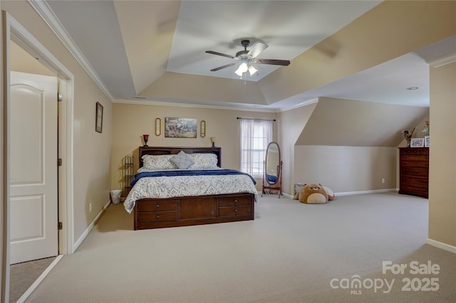 carpeted bedroom with ceiling fan, baseboards, a tray ceiling, vaulted ceiling, and ornamental molding