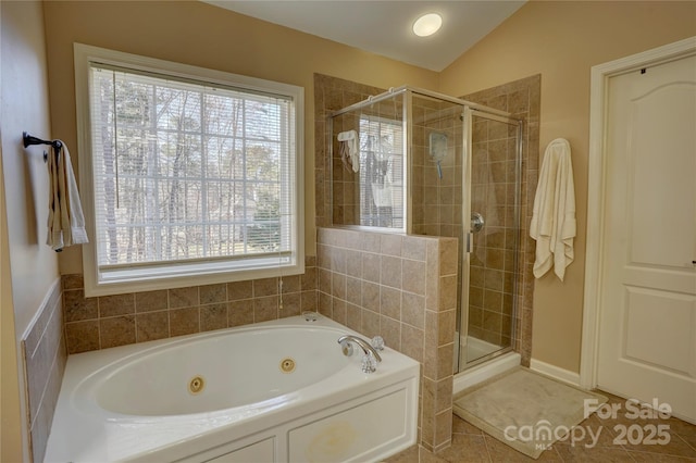 bathroom featuring tile patterned flooring, a tub with jets, a shower stall, and vaulted ceiling