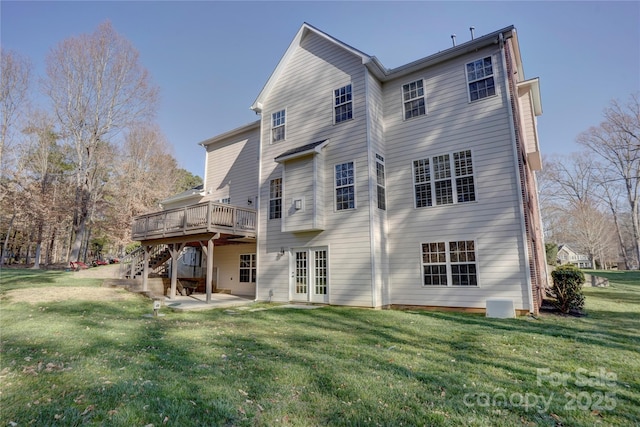 back of property with a deck, a patio area, stairs, and a lawn