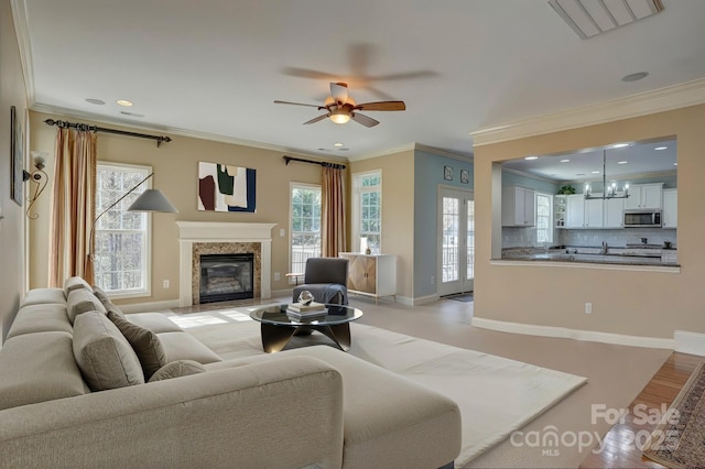 15100 Durmast Ct, Mint Hill, NC 28227 - living area featuring ornamental molding, baseboards, a fireplace, and ceiling fan with notable chandelier