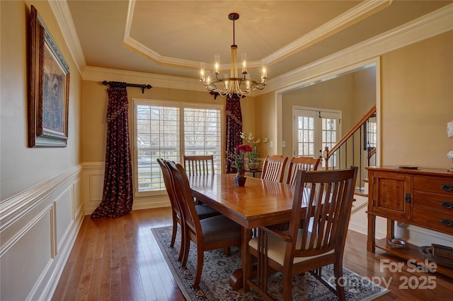15100 Durmast Ct, Mint Hill, NC 28227 - dining area featuring a raised ceiling, a notable chandelier, hardwood / wood-style flooring, crown molding, and wainscoting