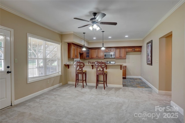 15100 Durmast Ct, Mint Hill, NC 28227 - kitchen featuring stainless steel microwave, light carpet, a peninsula, brown cabinetry, and ceiling fan