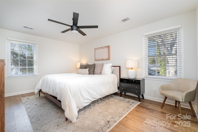 bedroom with visible vents, baseboards, and wood finished floors