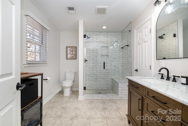 bathroom with vanity, a shower stall, toilet, and visible vents