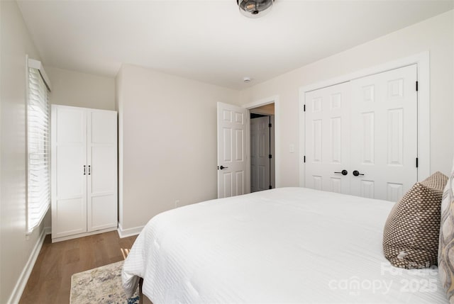 bedroom with a closet, baseboards, and wood finished floors