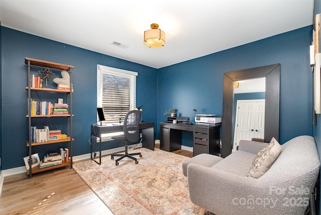 office with visible vents, baseboards, and wood finished floors