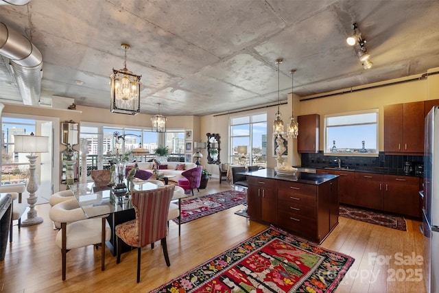 kitchen with a chandelier, dark countertops, a center island, and light wood-style flooring