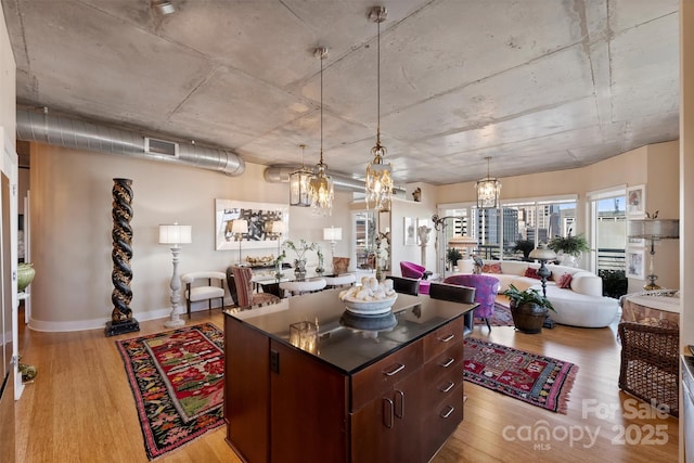 kitchen featuring dark countertops, light wood-style floors, a kitchen island, and open floor plan