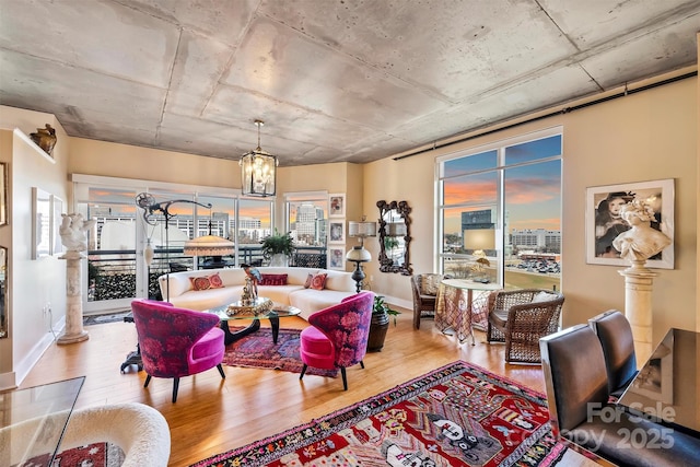 living area with a chandelier, wood finished floors, and baseboards