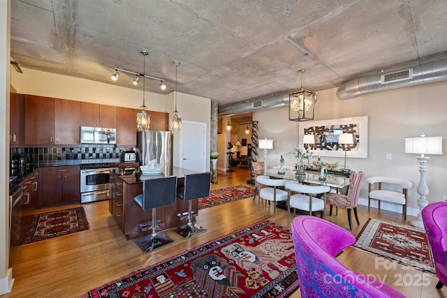 living area featuring a chandelier, visible vents, and wood finished floors