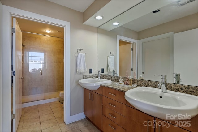 full bath featuring visible vents, a sink, a shower stall, and toilet