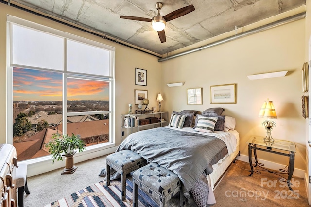 bedroom featuring a ceiling fan, multiple windows, baseboards, and carpet flooring