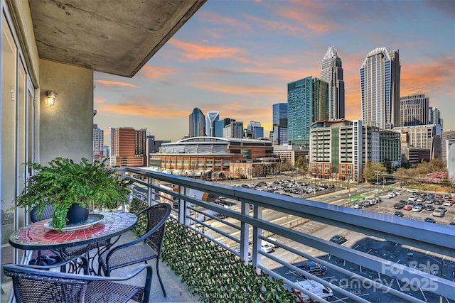 balcony at dusk featuring a view of city