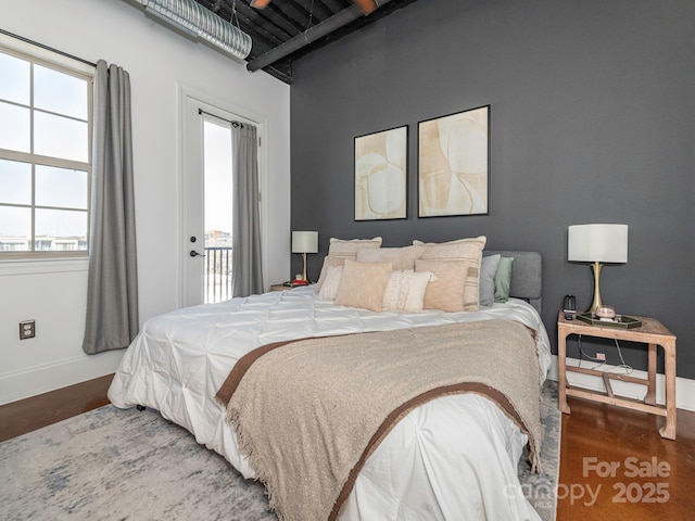 bedroom featuring access to outside, baseboards, and wood finished floors