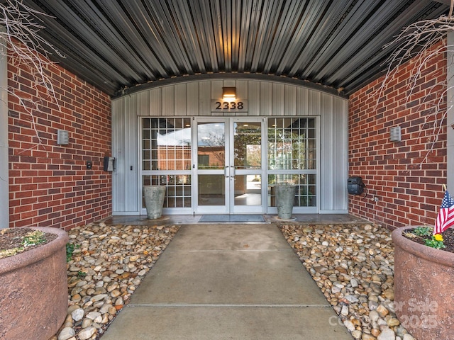 property entrance featuring french doors and brick siding