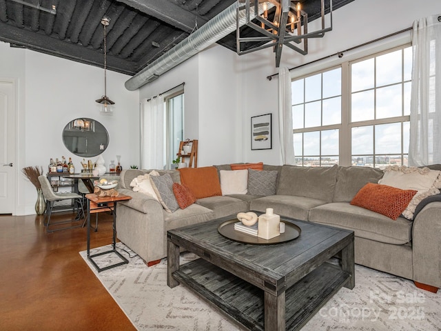 living area featuring finished concrete flooring and a high ceiling