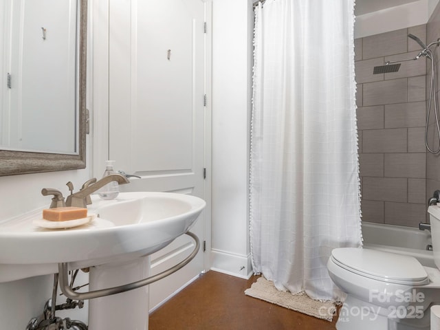 bathroom featuring toilet, baseboards, and shower / bath combo with shower curtain