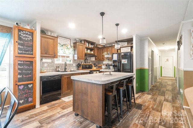 kitchen with light countertops, light wood-type flooring, black appliances, open shelves, and a sink