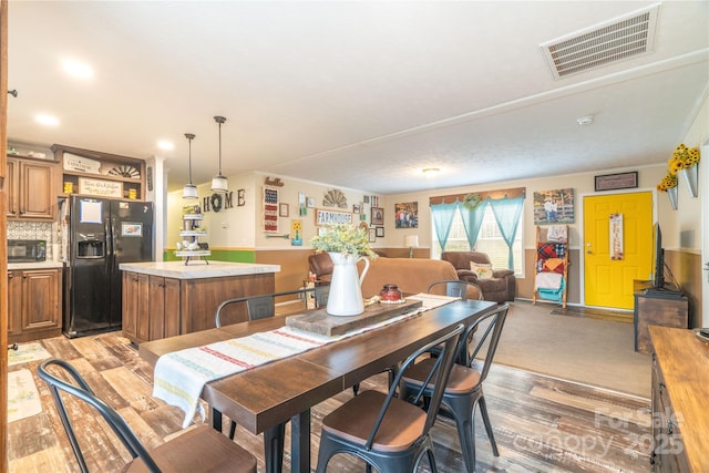 dining space with visible vents and light wood-style flooring