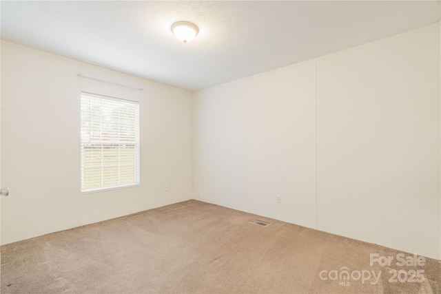 empty room featuring carpet and visible vents