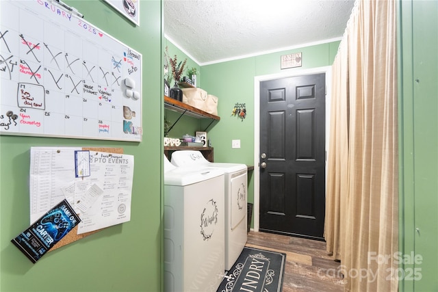 laundry room featuring a textured ceiling, laundry area, wood finished floors, independent washer and dryer, and crown molding