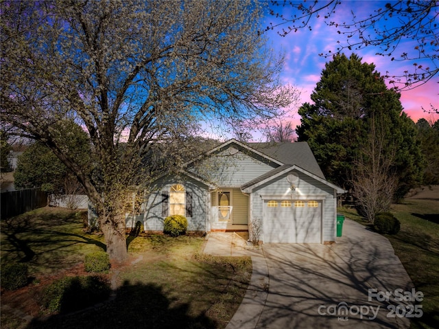 view of front facade featuring a garage, fence, a front lawn, and concrete driveway